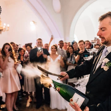 Simon at One Marylebone Wedding in London, showing his guests how to open a bottle of champagne with a sabre, before elegantly pouring the wine onto a champagne tower.