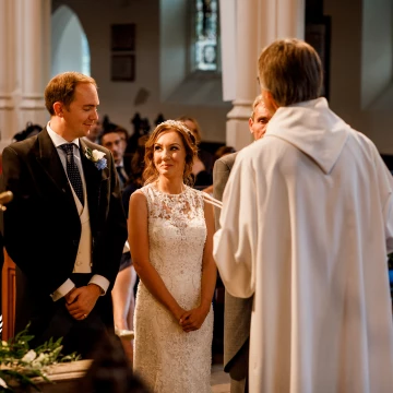 A cheeky moment between Andrea and Andrew at the ceremony - a loving and knowing glance and a stolen shot from me as the vicar told me I was not to be in front of the bride and groom! <br />
Taken in Wimbledon, South West London.