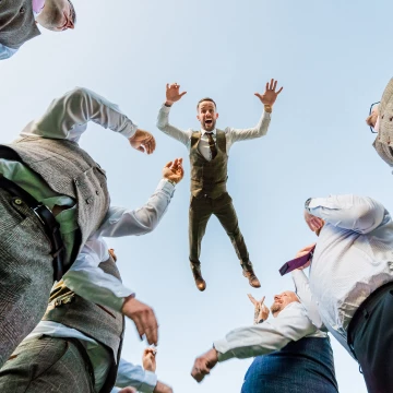 Love this. I had a chat with the groom about an idea and he was game. I laid on the floor and directed the groomsmen to stand either side of me and the groom jumped on their arms so we were. literally eye to eye. after several Hugh throws in the air trying to get a shot where arms weren't crossing the groom's body I nailed it.