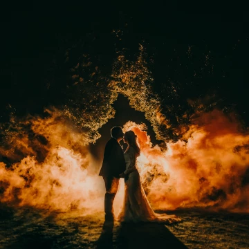 To create this awesome smoke silhouette I stacked two flashes behind the couple. One about 8ft behind for the rim and to light the smoke the other about 20ft back behind the trees to separate the trees from the background. Without the 2nd stacked flash for the trees, you would not see the tree outline in the photo. enjoy.