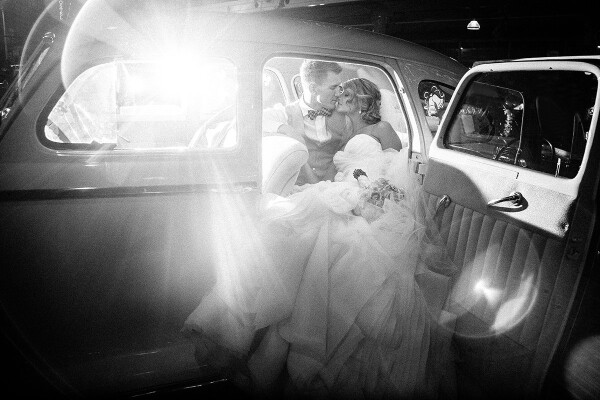 After their wedding reception in downtown Seattle, WA, the bride groom and I headed to the city next by the famous Pike's market to get some night shots in the middle of all the hustle and bustle. After taking some photos on the cobble stoned streets, I asked the lovely couple to take one last image in the car, and had my assistant light them from behind the car on the other side. We ended up creating the striking light as the couple leaned in for the last kiss of the night!