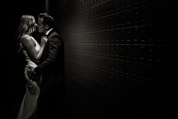 We like to capture what we call a ‘kiss goodnight’ shot of our bride and groom during their reception. It usually serves as a perfect image to end their wedding album.  This shot was in an unusual location. We noticed the hallway into the ladies bathroom at the reception venue had textured wallpaper and dim lighting - we knew it would be perfect for our shot. Although we got a couple of strange looks from some guests, capturing a sexy, intimate moment between our newlyweds outside the toilet, everyone was amazed at the end result. We used a couple of torch lights to give us enough light to create the image and our couple enjoyed their moment alone. We decided to finish this in a sepia tone, it matched perfectly with their classic, elegant outfits. Sometimes the most unusual locations make for amazing images - our couple loved this one, it’s a double page spread in their wedding album.