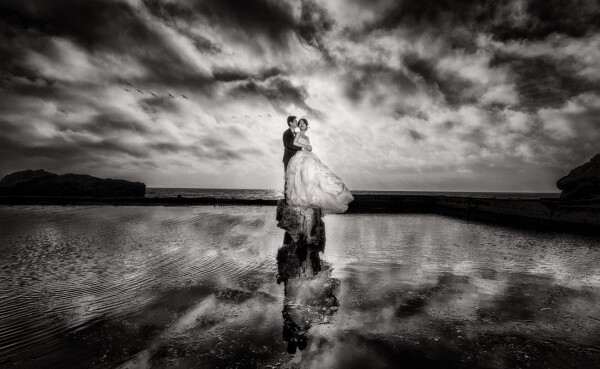 The evening was dark, windy, and cold with menacing clouds moving in.  The dress was also ruined after this session.  Despite the recipe for disaster, the couple could not have been happier with the image. 
