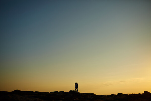 The picture was taken at Stanage Edge in Derbyshire UK. We delayed the engagement shoot by a day to get a better sunset. There were many shots taken on what was a fabulous shoot, but this one stood out, and the second I saw the angle I knew it was a winner!