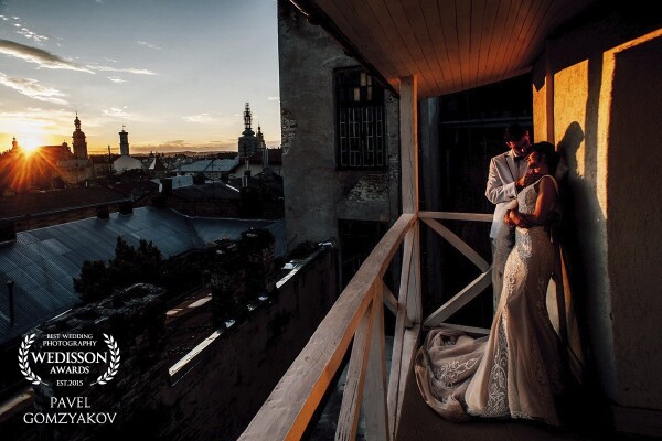This photo was made in the historical center of Lviv. Sunset sun gently warms the newlyweds. Alexander and Renata are now really in love and happy! A beautiful view of the ancient buildings from the balcony complements the picture of this romantic evening.