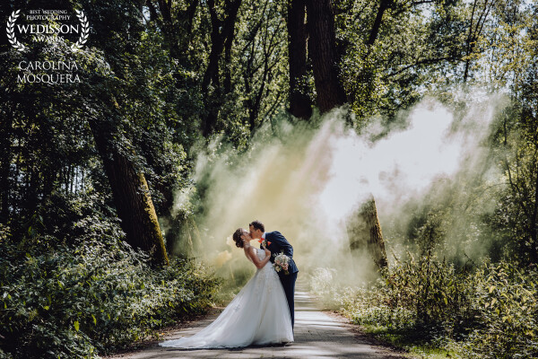 This image was taken last summer in Belgium. We are always chasing the light. The light was peeking through the trees, so it was the perfect moment to use a smoke bomb. 