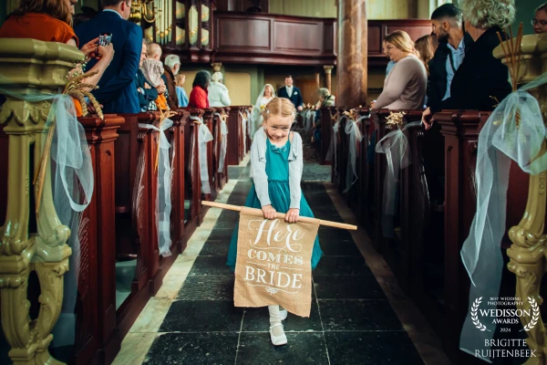 This bridesmaid was very shy about walking in the front of the church with the sign that the bride a...