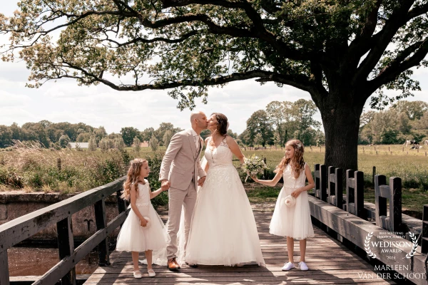 a beautiful couple with their two daughters at the water mill in Oele