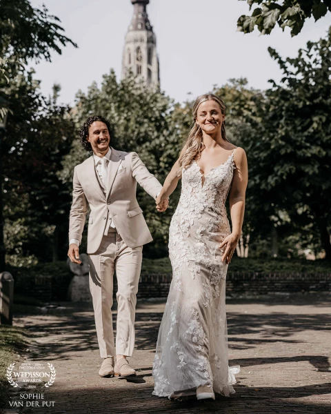 Newlywed couple photographed hand-in-hand in the center of Breda, The Netherlands. It was a sunny da...