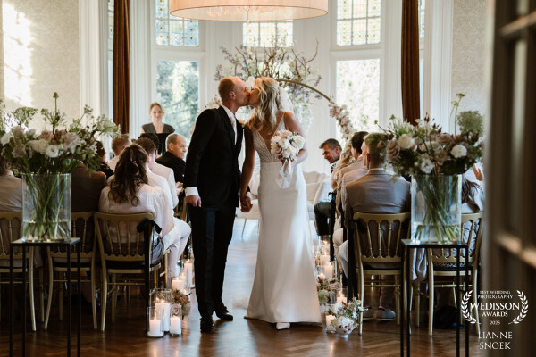 A kiss when walking down the aisle, in Kasteel de Hooge Vuursche, The Netherlands.