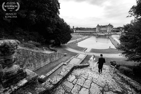 Louise & Guillaume walking toward the Castle of Roche Courbon in Charente, the magnificent place of...