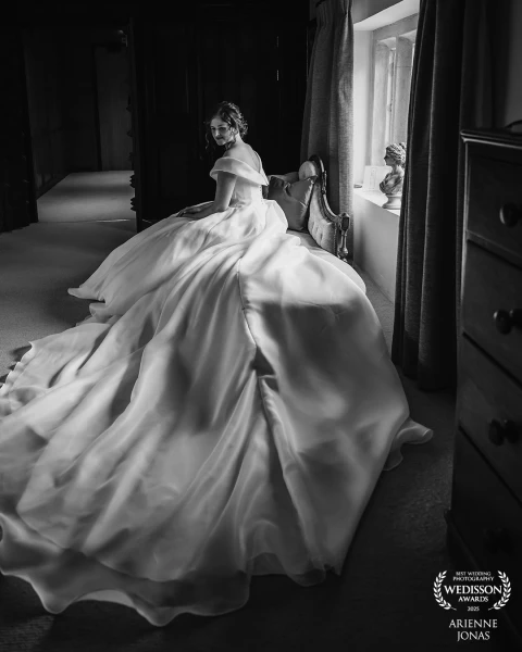 Bride is ready and taking a few moments as she listen to the rain outside and looking at her beautif...