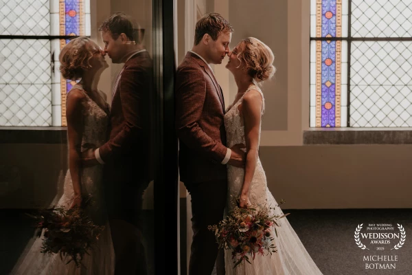 Not a pose. Just a pause. The couple leaning against the window of an old church, with their reflect...