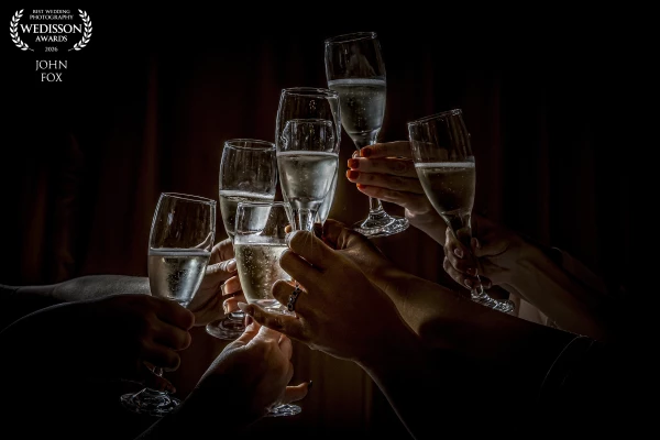 Bride tobe and bridesmaids champagne glasses all together with the engagement ring showing on the br...