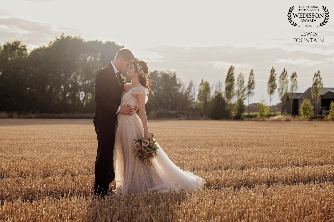 We had some beautifully soft early evening light when we took Lauren & Dan for a walk around Bassmead Manor Barns’ freshly cut wheat fields. <br />
<br />
Lauren’s dress caught the light perfectly, as the couple enjoyed a romantic moment together.