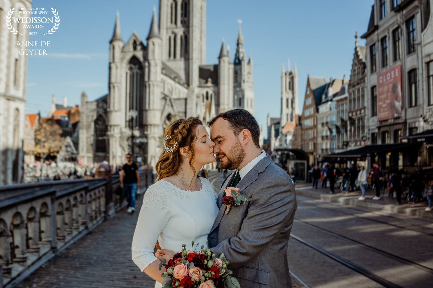 Kriszti and Steven choose Ghent as the perfect scenery for their wedding shoot.<br />
The tree towers in the back are typical for Ghent. Most beautiful is the way they seem to stand still in the busy city life. The way she kissed him, perfect moment