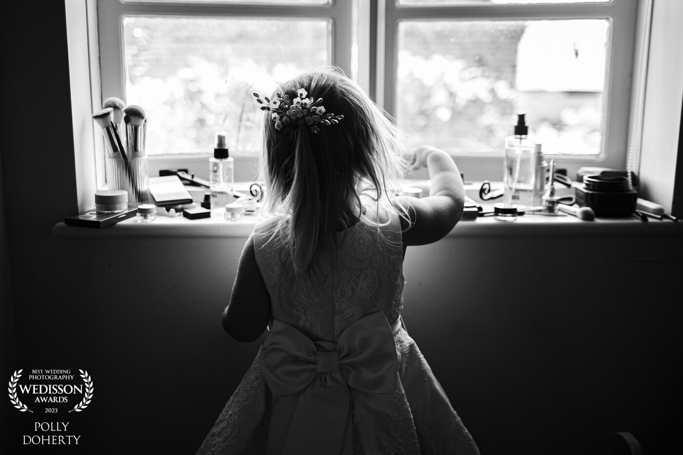 Little girls love to role play, she was keen to play with all the make up brushes on the windowsill. Simple real moment captured here at Park Farm Weddings, Northampton.
