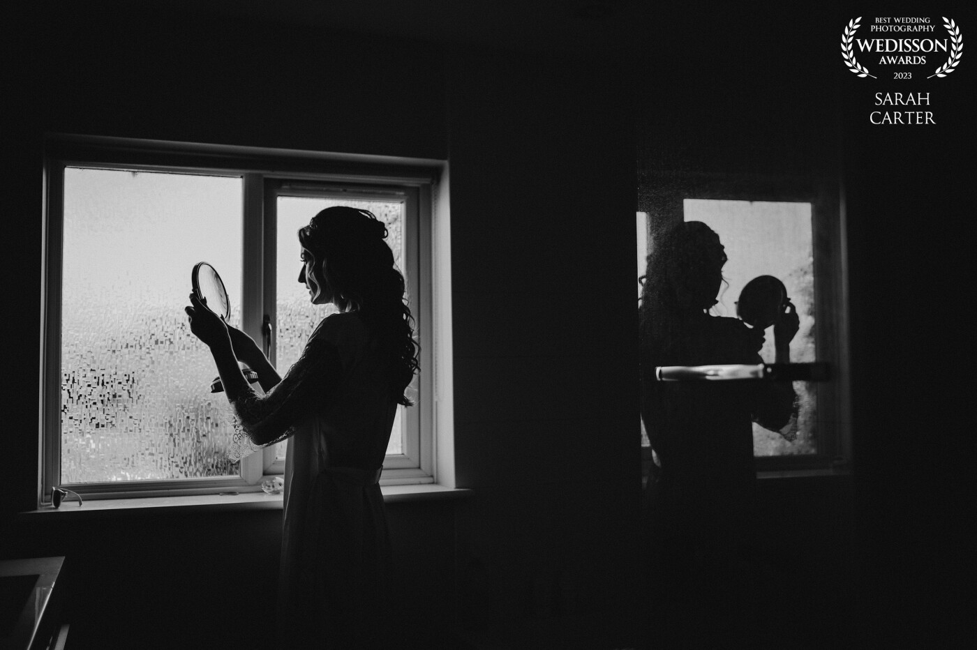 This was shot just before Izzy was putting on her wedding dress. The last minute make up check. Her reflection in the shower door is what caught my eye and I love how this image turned out.