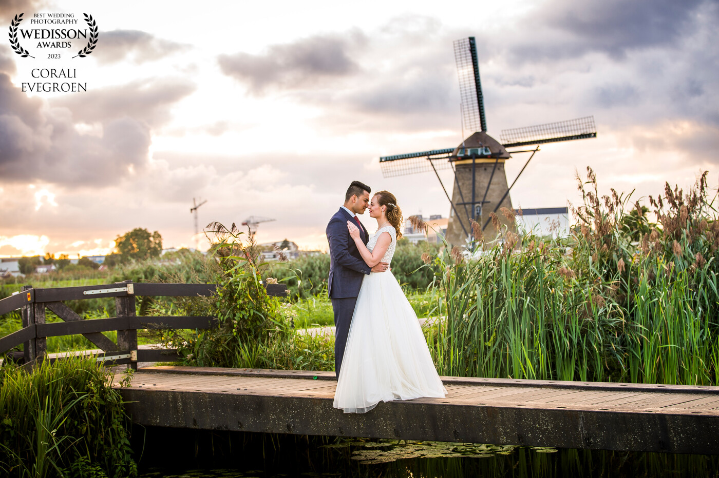 A beautiful sunset with a beautiful bridal couple at the famous windmills of Kinderdijk in the Netherlands