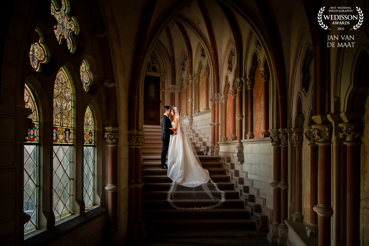 This image is shot at an unique location. The location still exists but it is not allowed to get here anymore. I had placed the couple on the stairs and put a flash on a lightstand just behind the wall. I love the warm colors of the wall and the almost medieval setting.