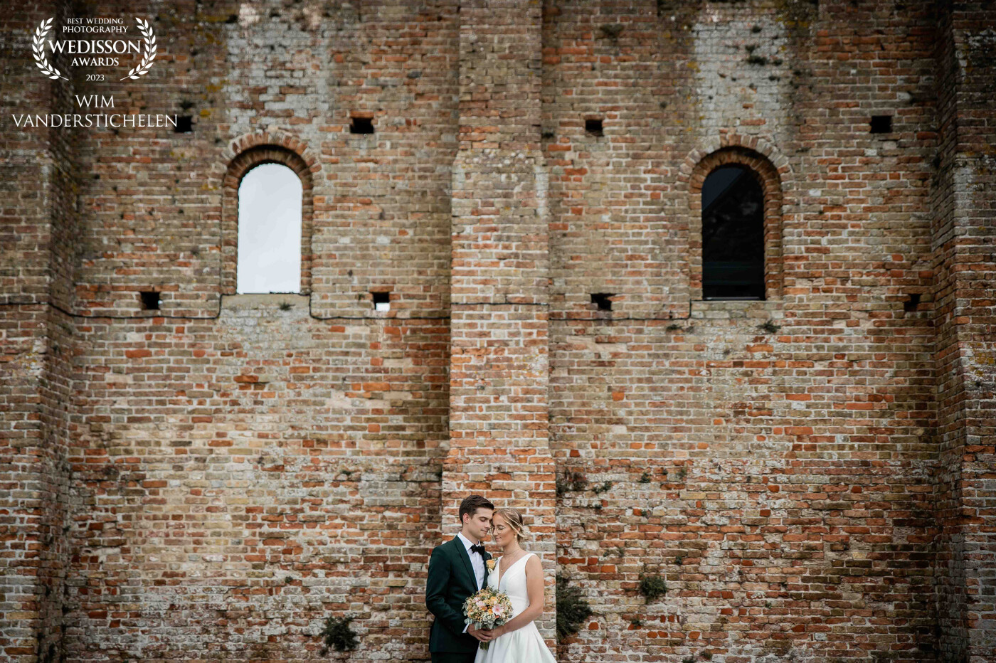 This photo was shot at an old abbey in Koksijde (Belgium) who is now a museum. I just love the old brick wall!<br />
The couple was enjoying a tender moment just after they got married.