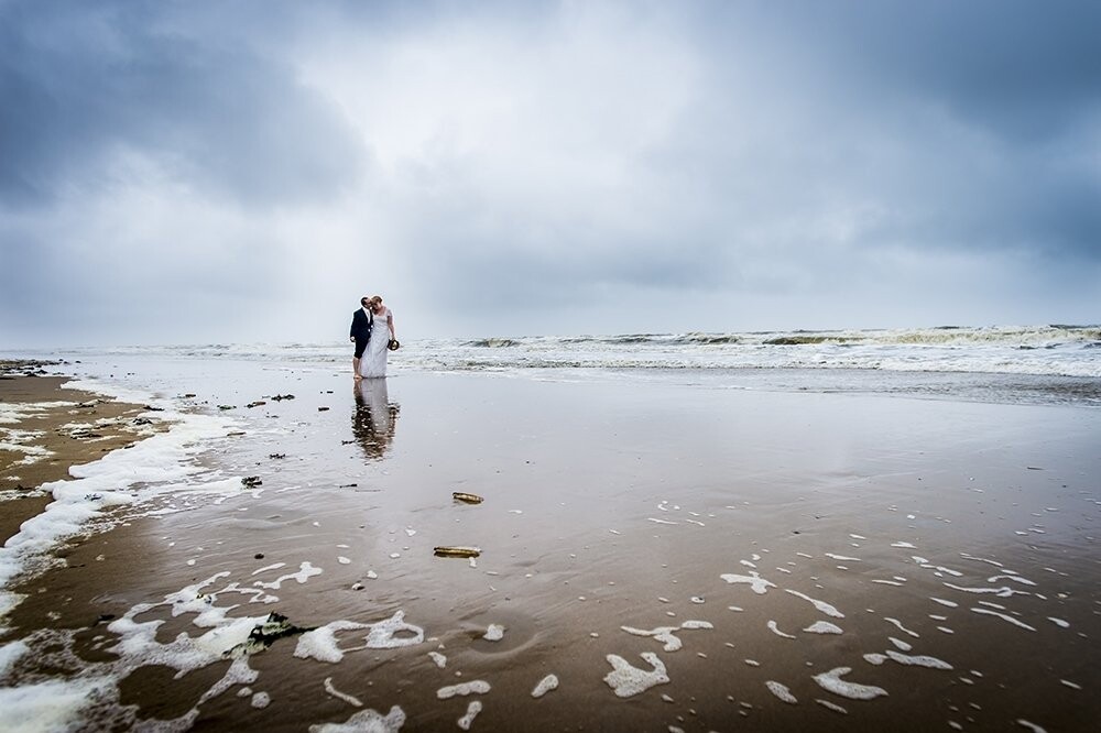 Wout and Anique celebrate their wedding day on the beach in Noordwijk the Netherlands. It was summer but on their wedding day it rained the whole day. It was cold and the wind was really heavy. But Wout and Anique had fun the entire day. We make pictures in the rain and storm. And in the afternoon they want to walk in the sea in the wedding dress and suit. My camera was soakingwet but we had so much fun this day.