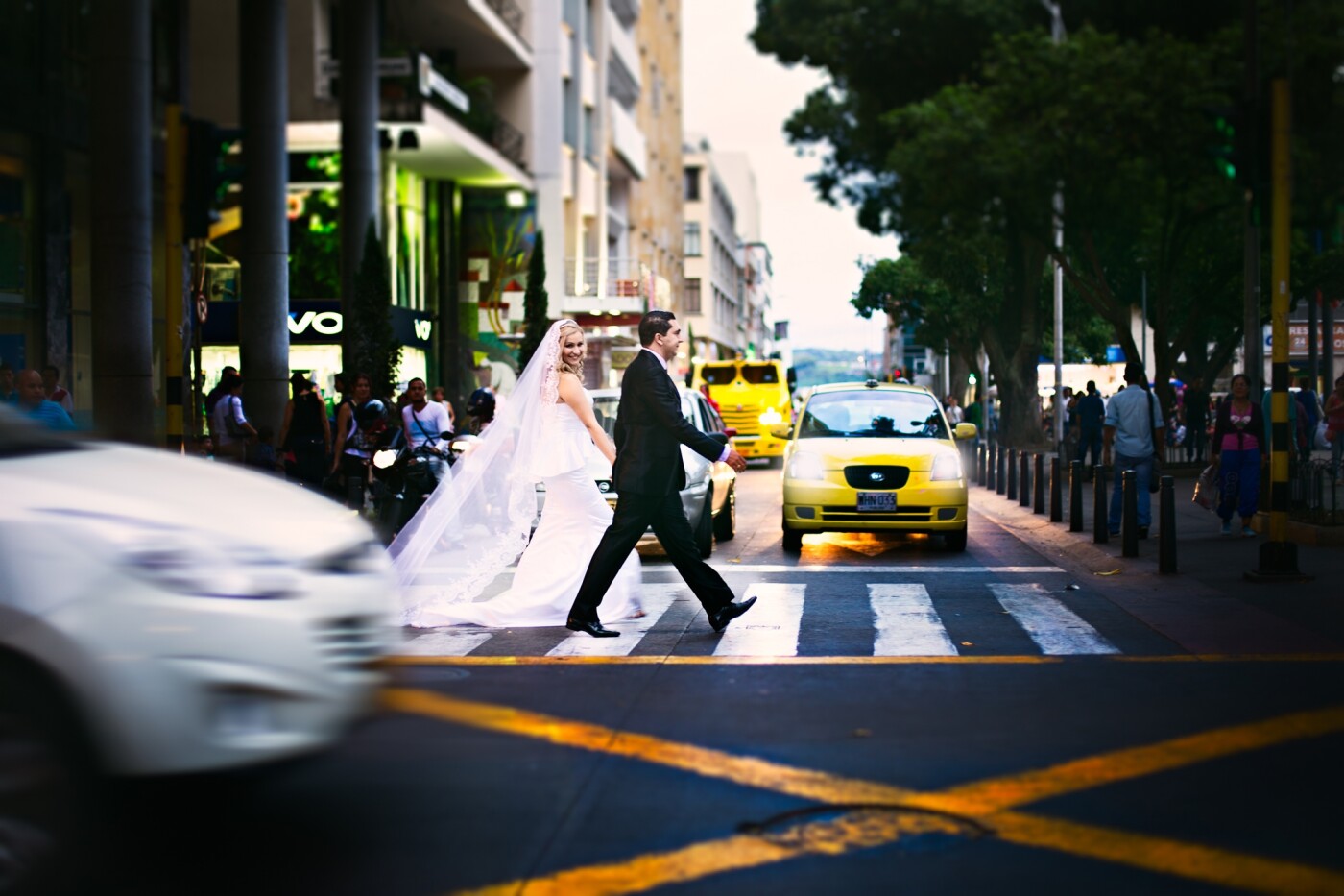I made this picture in one of the most important streets of downtown in my city Pereira, it is located 318 km from the Capitol of Colombia Bogotá.<br />
I asked the bride Luz Andrea and the groom Albeiro to please stand on one side of the traffic light and when the light permitted for the street walkers to pass the street, to please walk across it and for the bride to see towards the center of the street where I was located with my camera.<br />
This picture had to be done the faster way possible because I was in the middle of the street and I was stopping and complicating the traffic of this part of downtown . I wanted to do this picture because it's a place very famed and noticed to me and all the people of my region