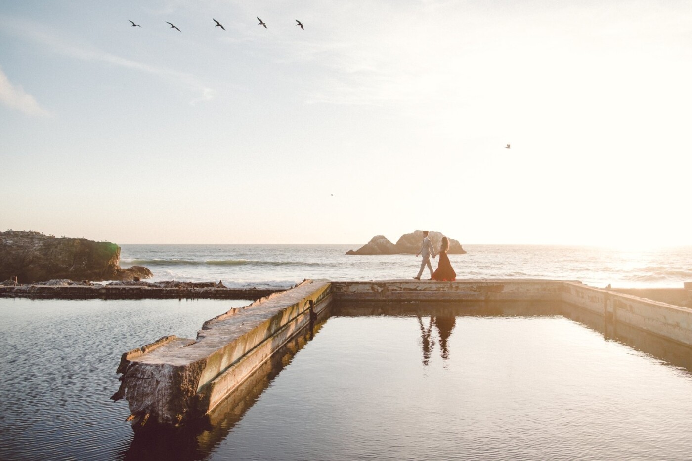 Here is where Anton took Lara’s hand and guided her across the old ruins of Sutro Baths in San Francisco. The ocean breeze caught her red dress and the sunset mirrored their reflection into the pool in front. The birds gracefully aligned into this frame and in the heartbeat of the shutter clicking, I understood that this moment was going to be timelessly captured. 