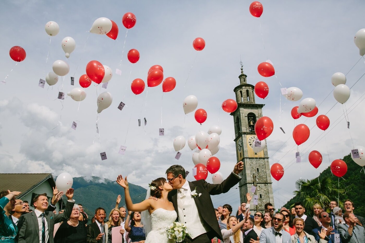 Anina & Sven celebrated their beautiful Swiss wedding in sunny Vallemaggia in Ticino. They asked their guests to write wishes on every balloon so they could send them off to the sky for good luck. Once I saw this moment was happening and that the clouds looked beautiful behind the church tower, I got on my knees to clean the background and filled the sky with the balloons, which certainly added a magical touch when capturing this moment. I loved how their family and friends cheered for them and how romantic and photogenic this rite was.