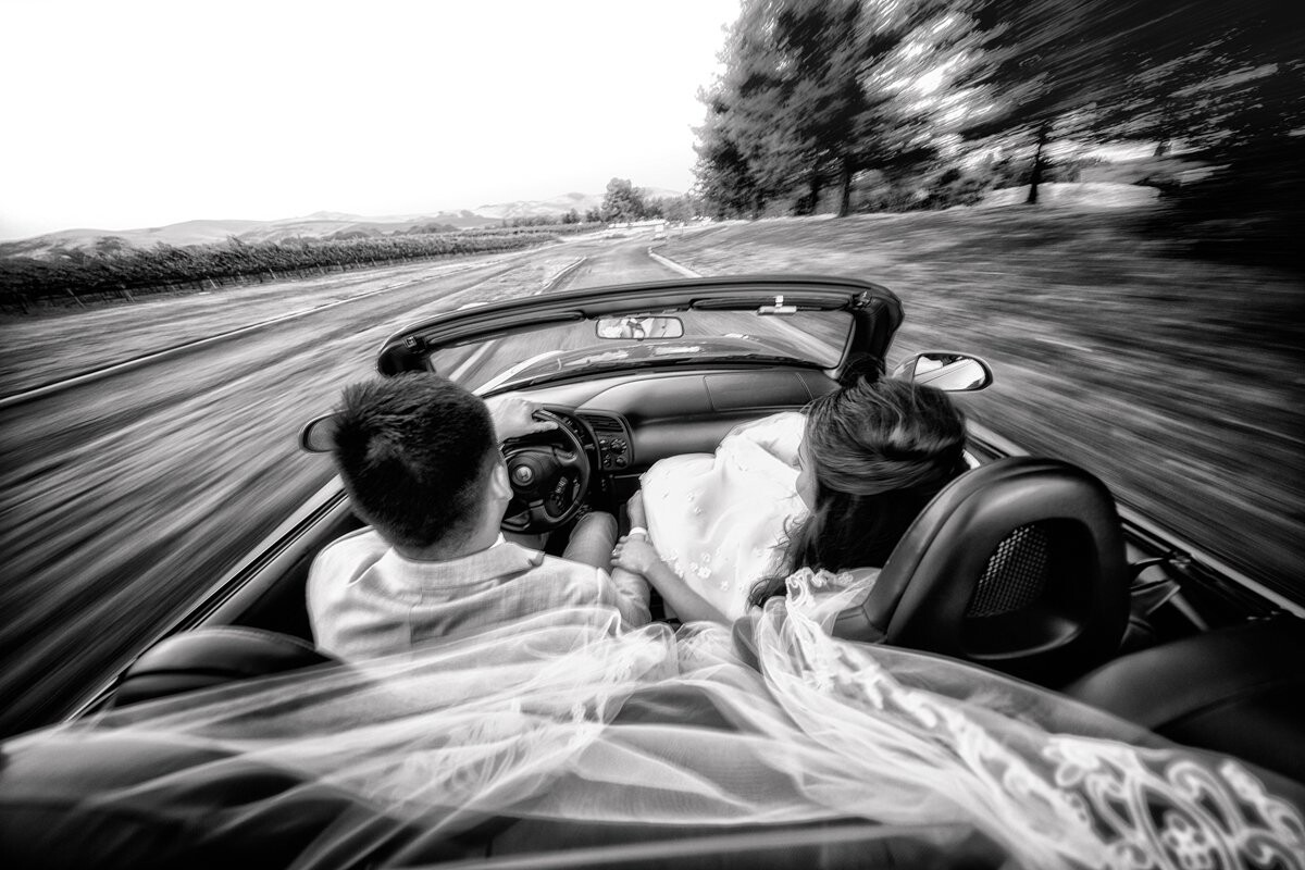 This is a two-seater car and I was sitting on the trunk, with the bride's veil getting tangled in my face.  The first time they drove off, I almost fell off.  But I had a blast!