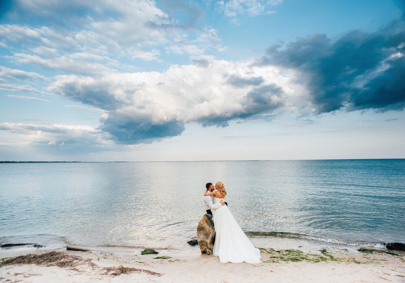 Azov Sea was especially romantic in the evening. Nature has created the perfect landscape for this beautiful couple! The bride Irina so tenderly embraces groom Eugene, as a beautiful sky reflected in the mirror of water.