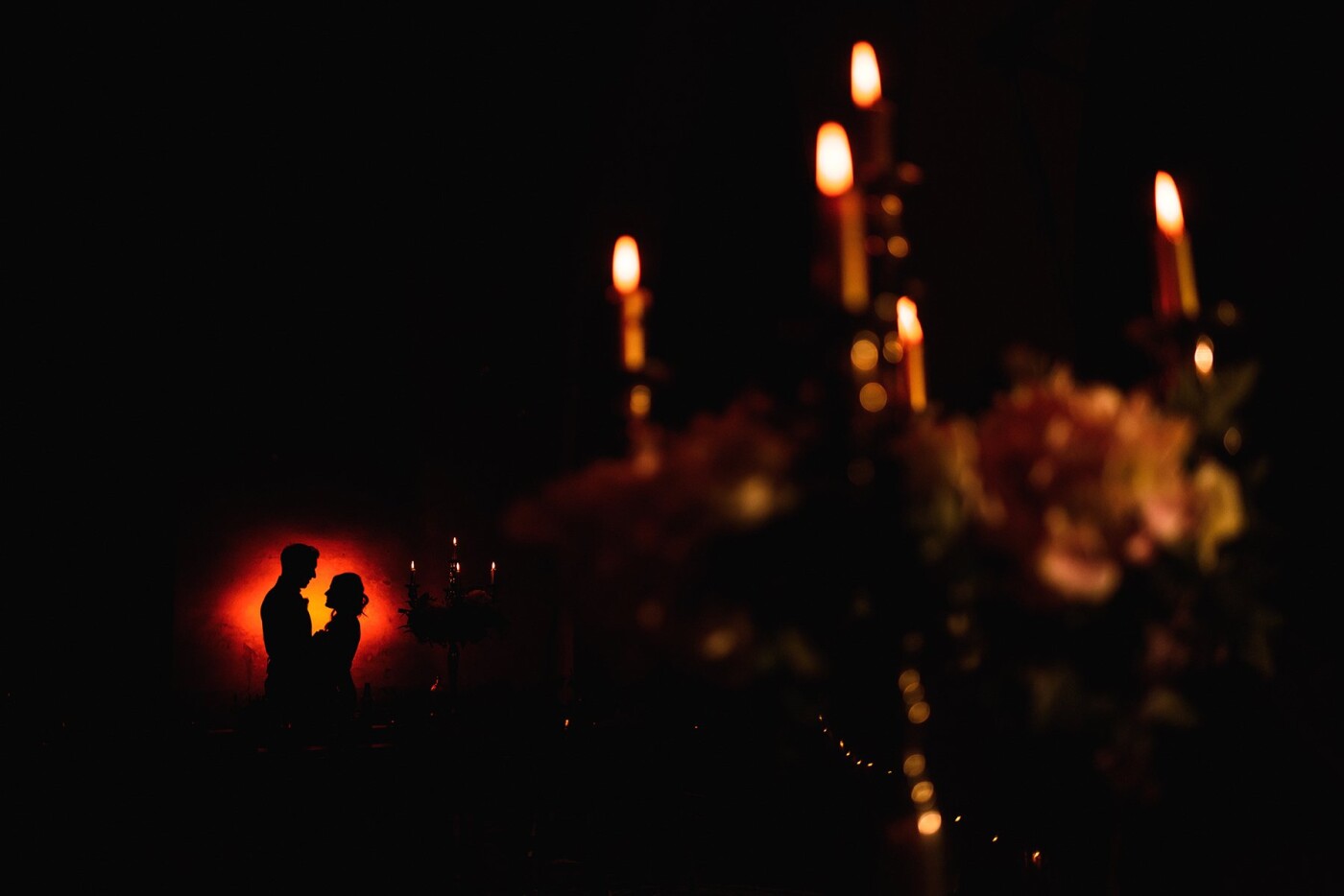 This photograph was taken at a wedding in Tuscany, Italy. I wanted the light behind the bride and groom to be the same as the colour of the candles in the foreground.
