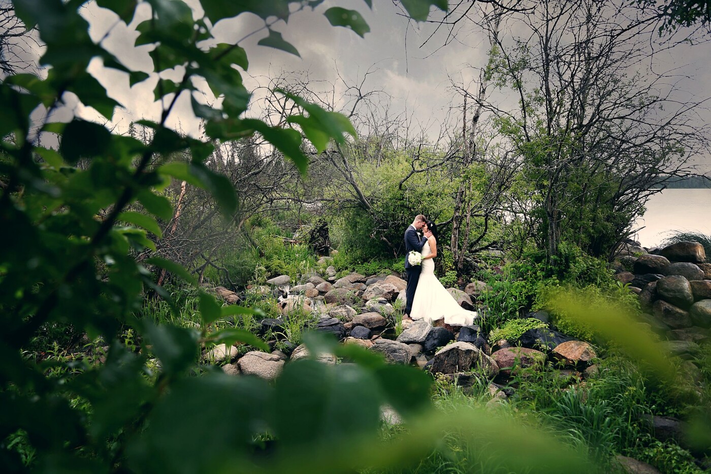 This photo of Jenny and Brandon was literally just taken a few minutes after their "first look" where they saw each other for the first time! Though you can not see it, the couple had to climb over water and rocks to get to the perfect spot for this photograph! It was raining a  little bit and the lush of the surrounding greenery was so beautiful! It was a perfect spot for the perfect couple! 