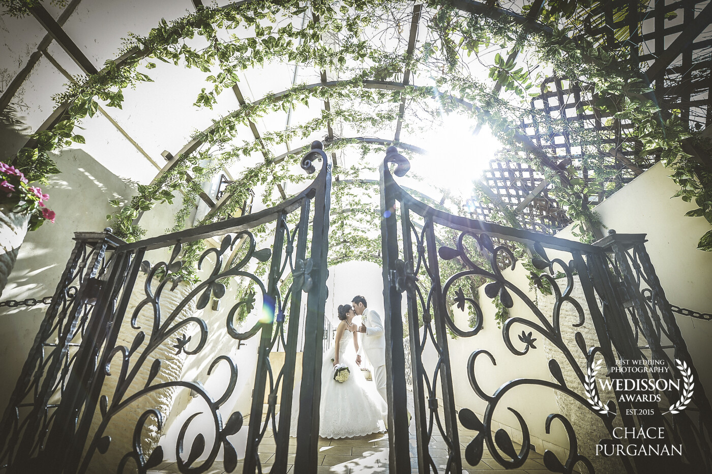 Sneaking a kiss and a "Shaka" in the secret garden. A beautiful moment taken outside the chapel after a lovely ceremony on a sunny day in Hawaii.