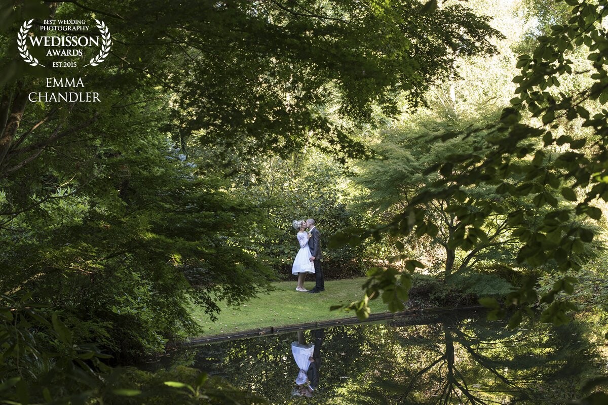 This was taken at a stunning venue in Hampshire called Rivervale Barn.    The bride and groom took a wander around the gardens and I snapped this from the other side of the lake just as they stopped for a kiss.    They are so love and were an absolute dream to photograph!