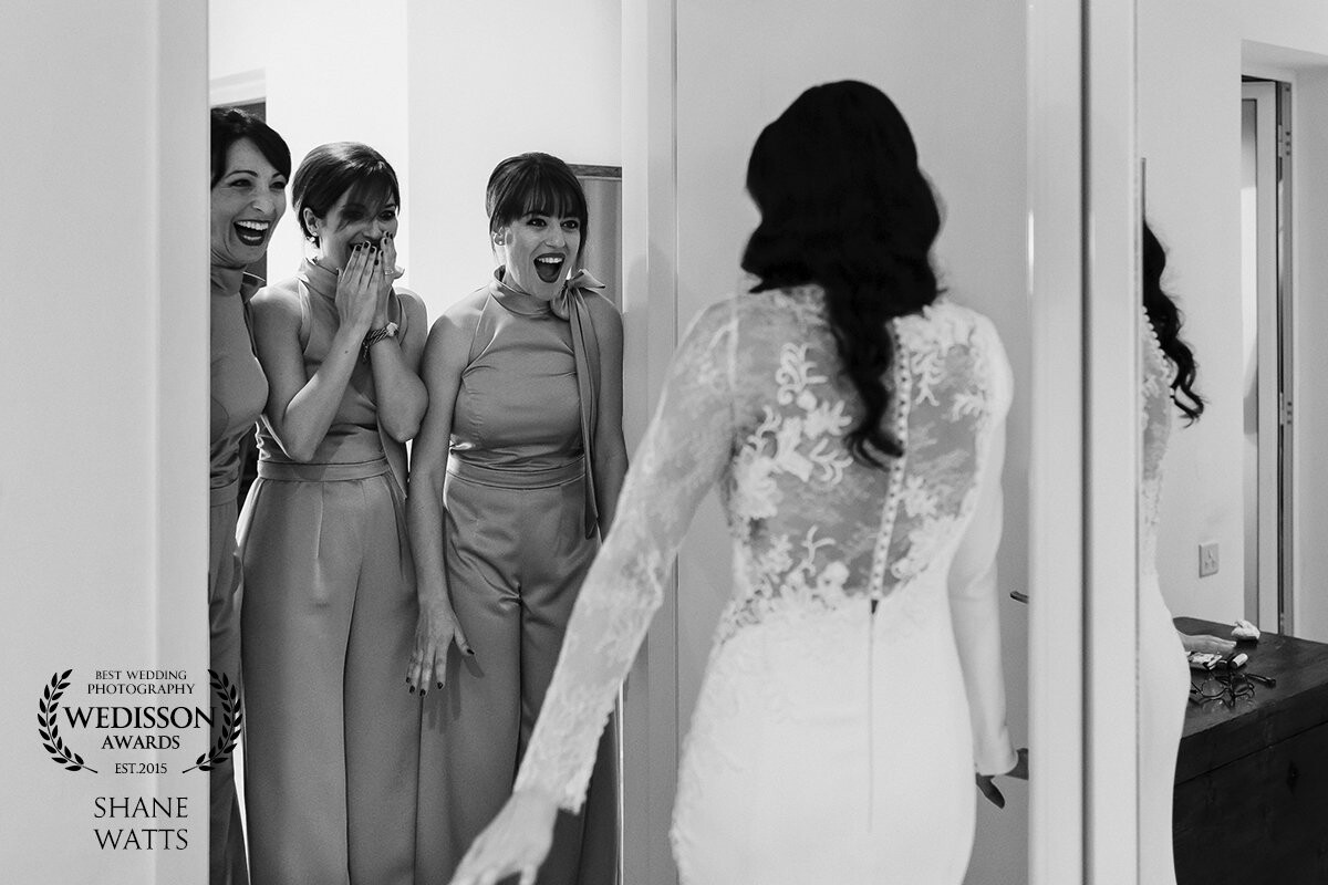The bride had managed to keep her dress details a secret even from her bridesmaids. After her mother helped her in the dress we called the bridesmaids in the bedroom to get their reactions. Kristina looked amazing, the girls reaction says it all.
