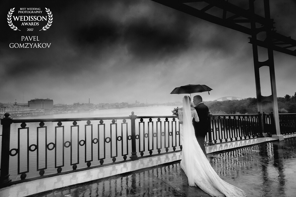 Vitaly and Anna are a sensual couple from Kiev. This photo was specially made in the state of the autumn city. The bridge over the Dnieper River, the overcast sky, streams of rain - all this enhances the romantic mood of the newlyweds. Now the bride and groom warm their feelings, their love is stronger than any bad weather.