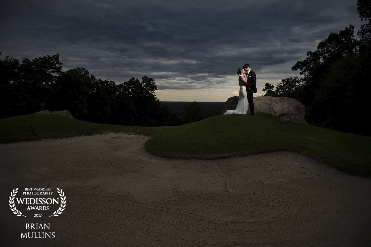 I love shooting on golf courses but trying to find "diversity" in the landscape isn't always the easiest. This photo was taken as the storm clouds were clearing up giving us a beautiful backdrop in the sky. The happy couple were actually already married and this was their reception for those who didn't travel abroad for their ceremony. As their wedding was less formal and held in a tropical climate, I think the contrast of a formal portrait on a golf course complimented their reception feel.