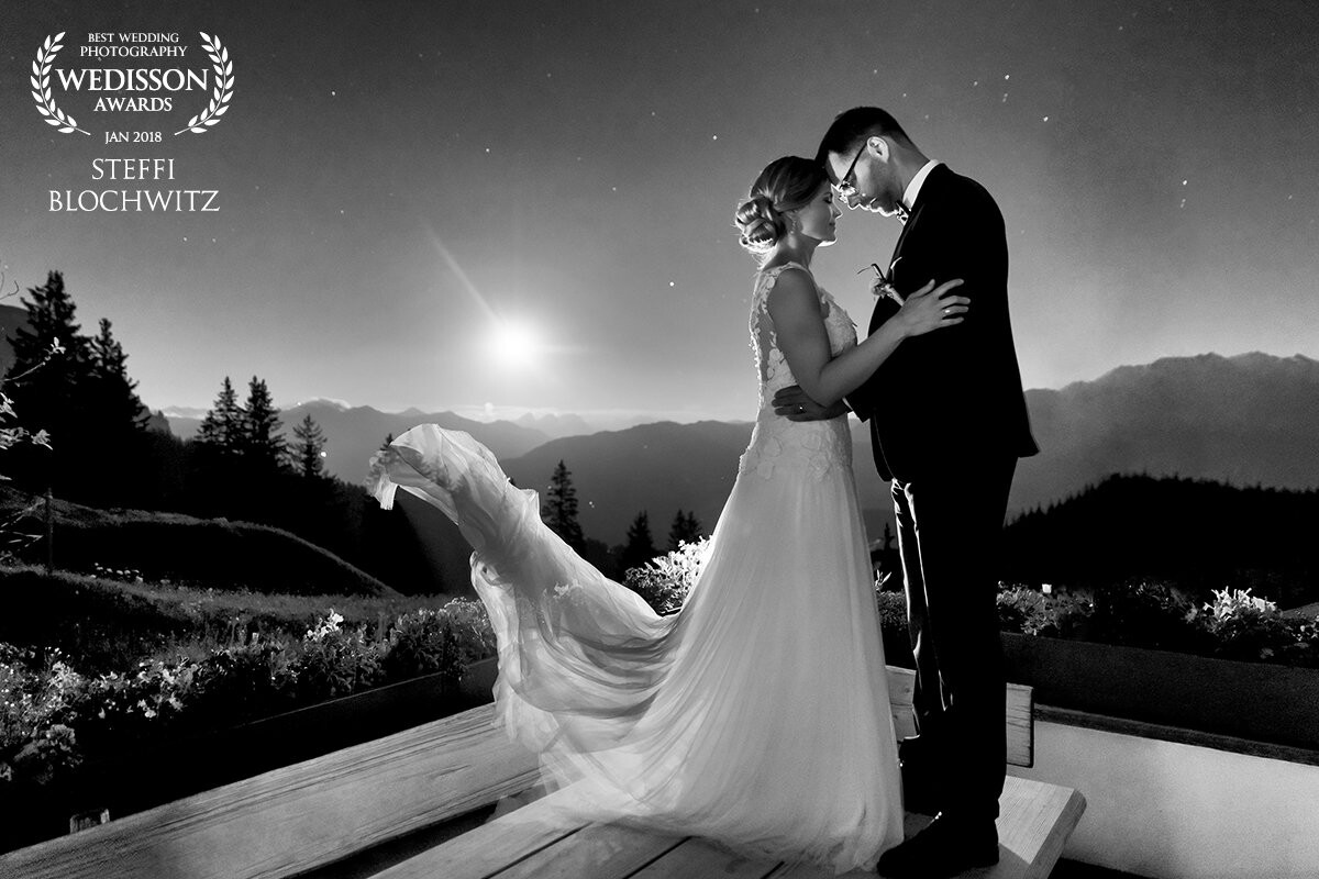 It was a beautiful sunny day in the swiss alps. After the ceremony we went up to the swiss charlet "Startgels" in Flims to celebrate. After a stunning sunset we got an incredable moon rising over the mountains. For this photo my lovely couple was standing on the table while the best men through the brides dress into the air.