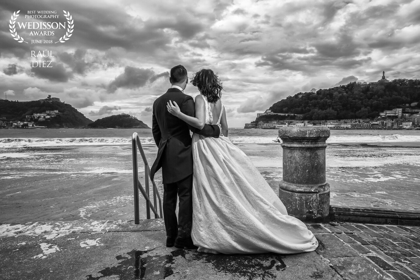 This image was taken on the beach of La Concha in San Sebastian during a post-wedding session. The cloudy skies threatened storm and were perfect to get a dramatic photo.