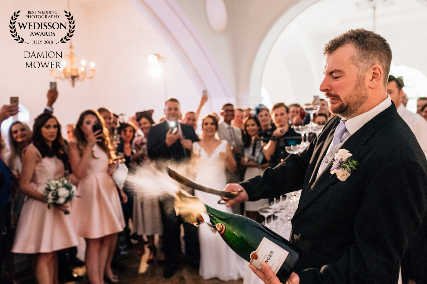 Simon at One Marylebone Wedding in London, showing his guests how to open a bottle of champagne with a sabre, before elegantly pouring the wine onto a champagne tower.