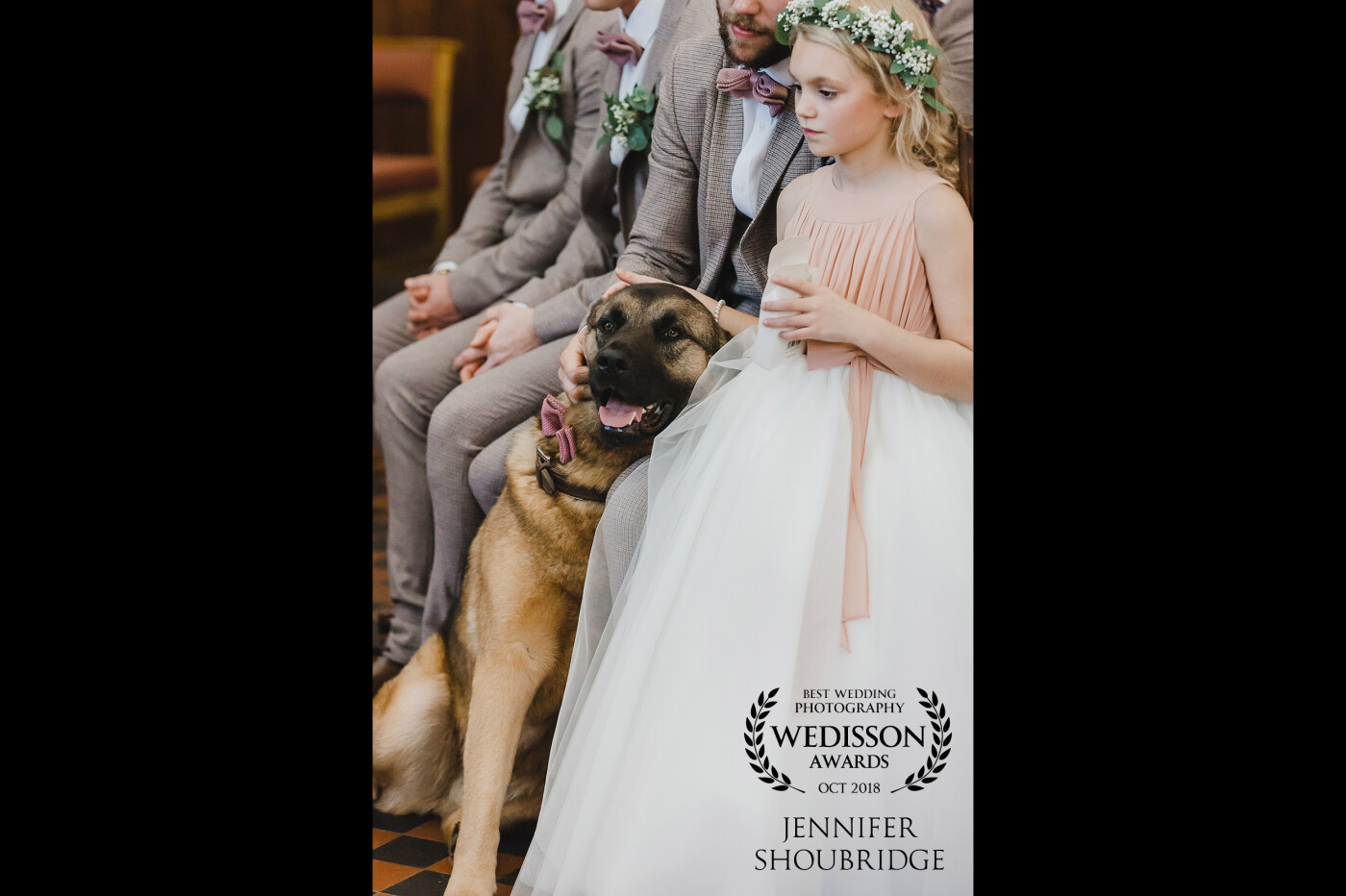This photo was taken in the Church as Georgia and Louis were getting married. Monty (the dog) had been a little lively, wanting to be by Louis's side, and so Bella stepped across the aisle a stood next to him gently stroking his head as he sat next to the best man Tom. It seemed to calm Monty as they both watch on the proceedings, and it was a really sweet moment between the flower girl and the ring bearer.