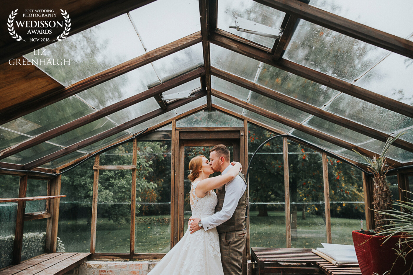 A dash to hide from the rain in this gorgeous wooden greenhouse. A sneaky kiss for these two and a moment alone at Hockwold Hall Norfolk.