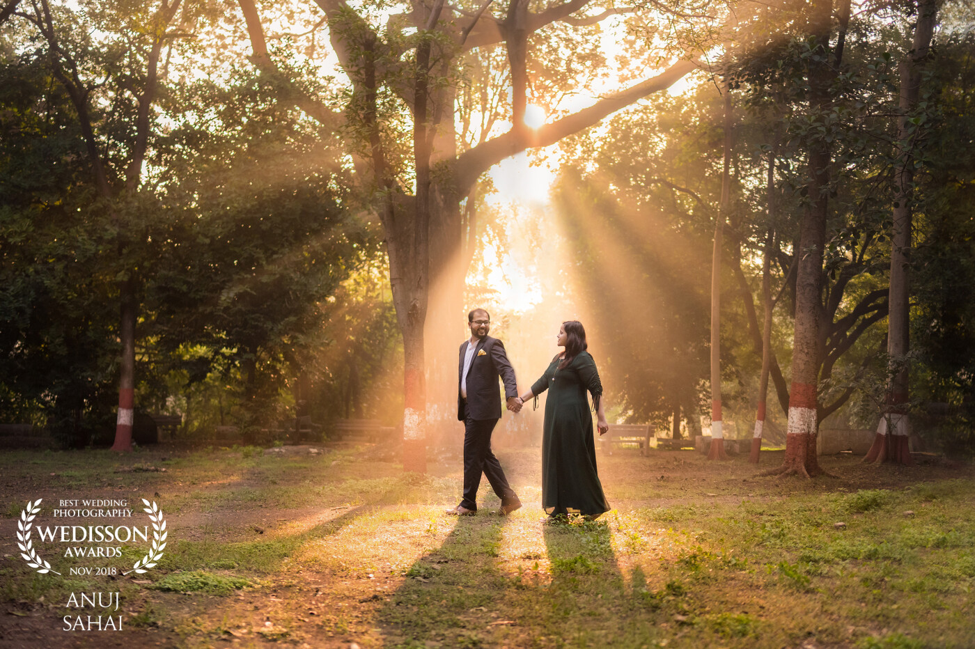 I went with the couple early in the morning basically to avoid crowds. While I was photographing the couple, I saw golden sunlight peeking through the trees. Rather than a typical couples pose, I went for "leading the way" shot and the golden light just adds spice to the photograph.