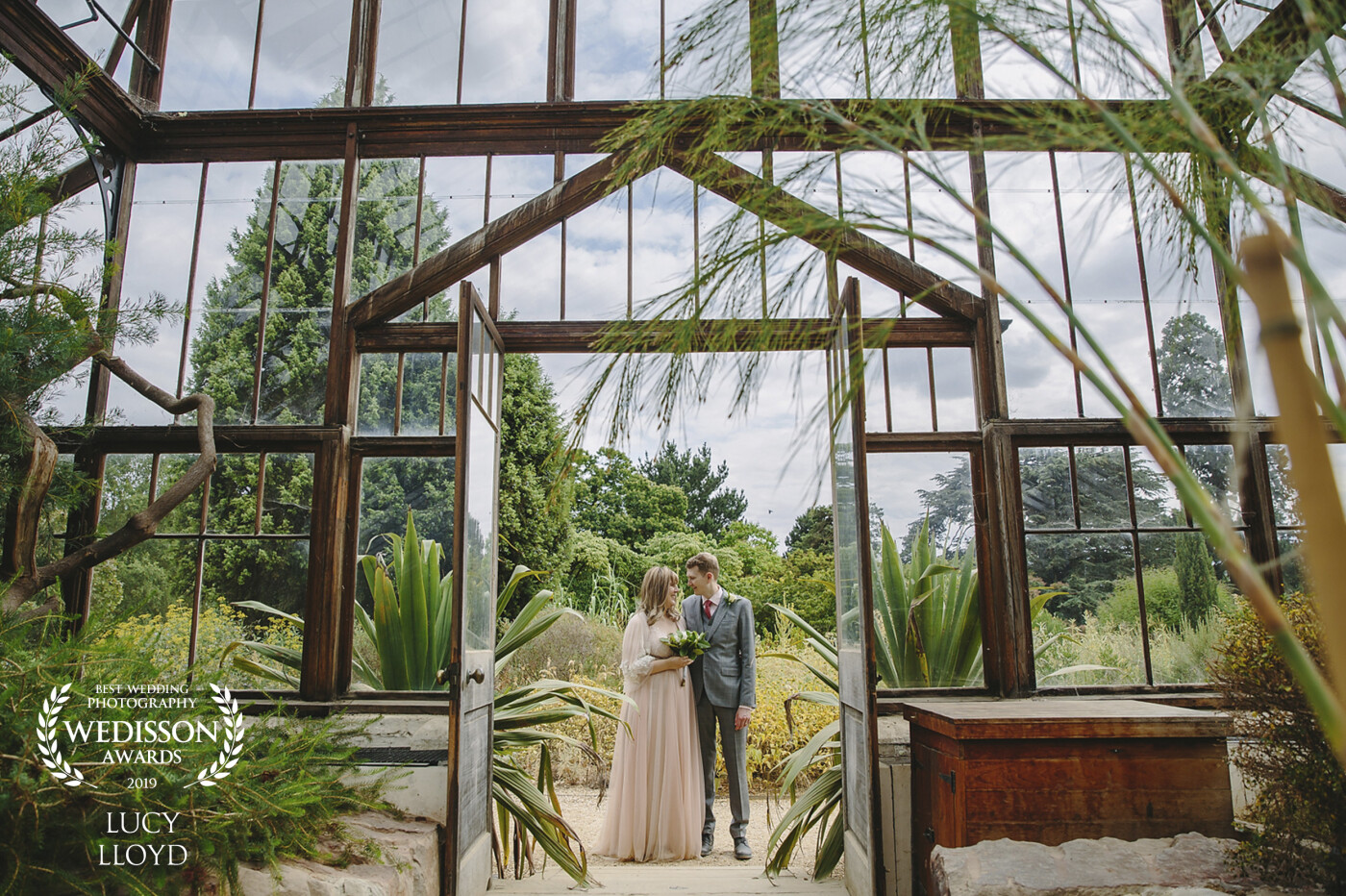 A moment from a lovely wedding at the botanical gardens in Cambridge.  <br />
We were experiencing a heat wave in the UK, and a lot of the grass was yellow, <br />
so I thought it would be a good idea to use the green houses in their portrait photos. 