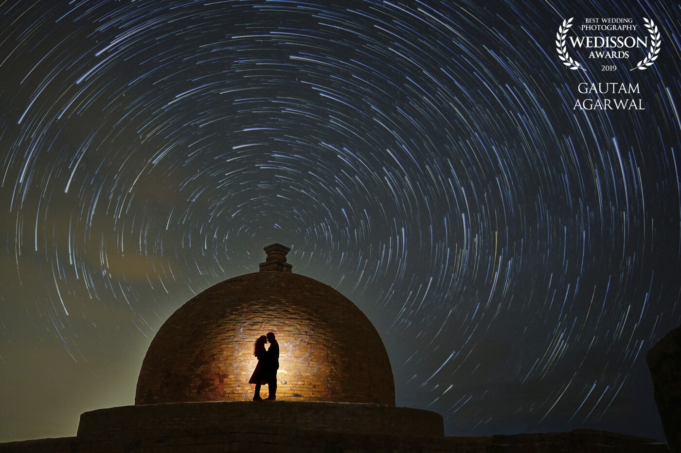 Thank you so much for recognising my work. I wanted to give something out of the ordinary to this couple. This building ( a Buddhist Stupa) has been our city's heritage and the sky was filled with stars. So the thought of a star trail portrait triggered