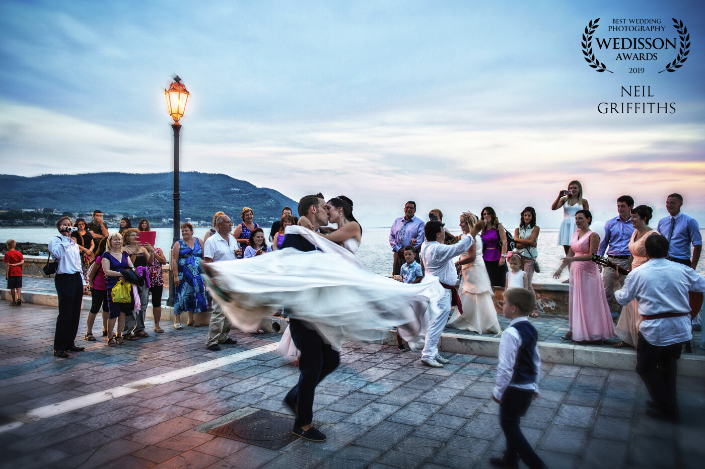 Taken at dusk in a place called Santa Maria Di Castellabate on the Italian coast. Steph and Danny were walking along the coastal path with their guests, when the local musicians broke into a rendition of Dean Martin's 'Amore'. A magical moment, it means a lot to me, because it tells the story of their wedding in one photo. 
