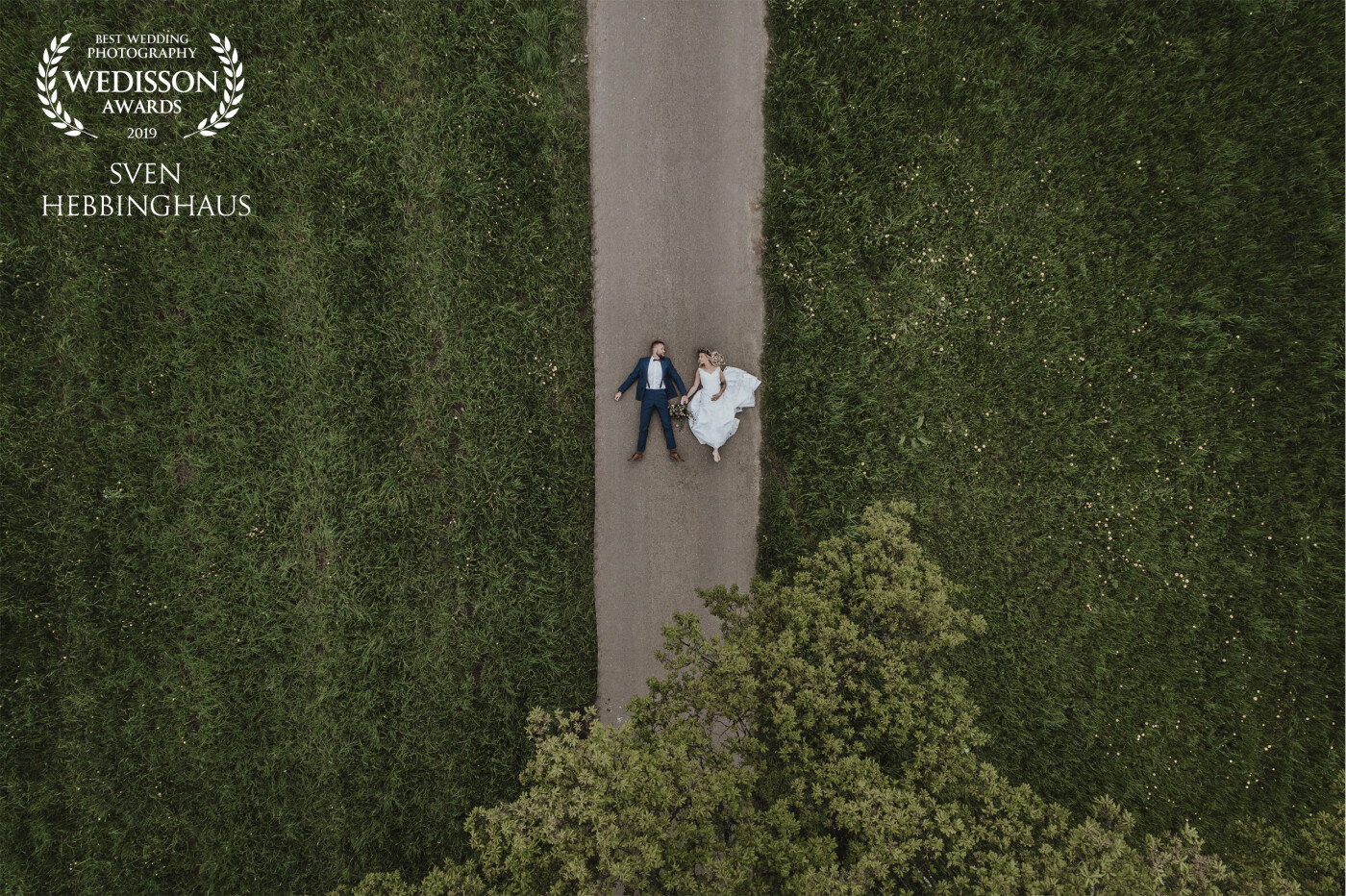 These two lovers were in the mood for an extraordinary wedding photoshoot. So I noticed the beautiful geometry of this landscape. This tree, the street and already the picture was in my head. My bridal couple lay down on the street and looked at each other in love. Just perfect.