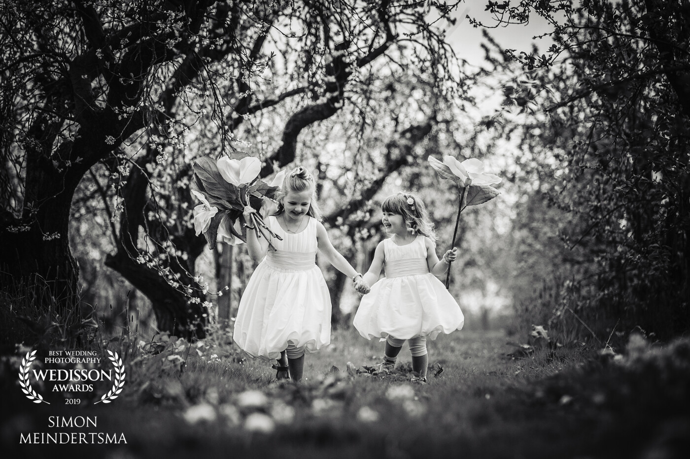 I just love kids at weddings, so pure they are! This was a setting in an apple tree garden where they just had some fun with big flowers running hand in hand.