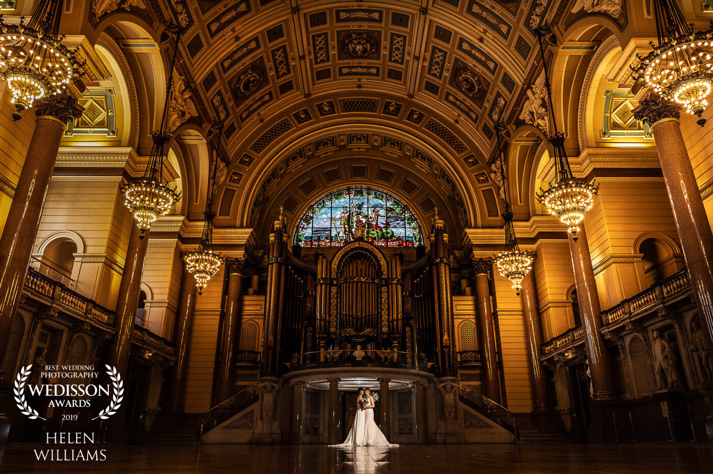 St George's Hall in Liverpool, UK is one the most beautiful venues I have ever shot at. This room, The Great Hall is regularly used for filming TV and film productions.  This space in particular was used for Fantastic Beasts and where to find them. A lot of wedding photographers prefer to shoot on the upper balconies that are bathed in natural light. The floor level here has no windows and more difficult to shoot, which is why i love it so much. As soon as i saw the stained glass, organ and beautiful chandeliers there was no way I was going to stay on the balcony and get the 'safe' shot. I took this using two AD200's. The first placed directly behind the brides pointing upwards to seperate them from the background and a second light camera right with grid to light the brides. This was edited out in post.   